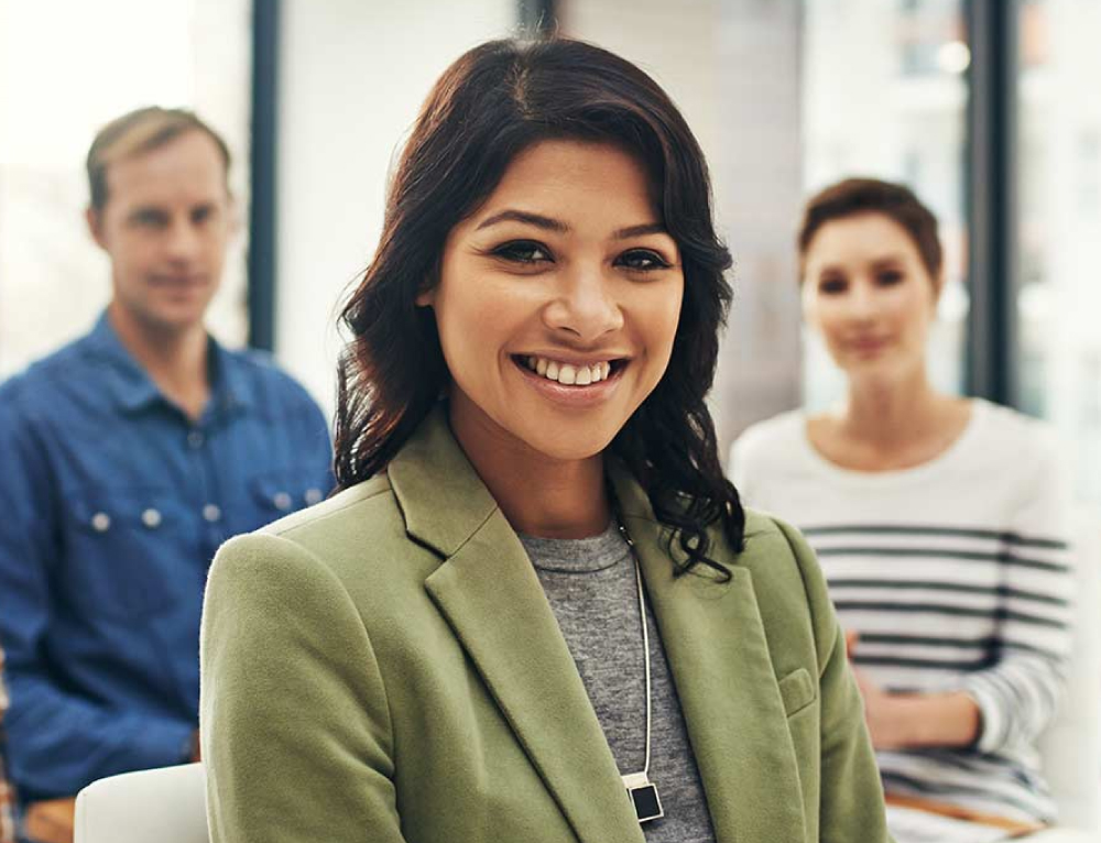 woman who is smiling and wearing a green blazer - New Perspective Careers Assisted Living Careers